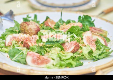 Eine gesunde vegetarische Vorspeise mit geschnittenen Früchten und knusprigem Gemüse, garniert mit Nüssen, serviert auf einem runden Gericht, das einen Lebensstil aus biologischem Anbau unterstreicht Stockfoto