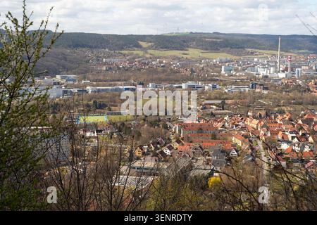 Großer Panoramablick auf eine Stadt, Wohnviertel, Industriegebäude, grüne Felder, Wälder, und Windturbinen auf fernen Hügeln. Stockfoto