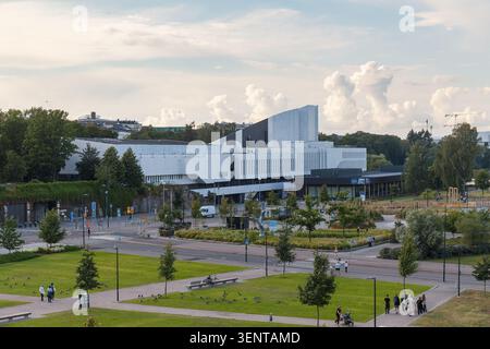 HELSINKI, FINNLAND - 11. AUGUST 2025: Panoramablick auf ein großes weißes modernes Kulturgebäude mit umliegendem grünen Park im Sommer. Stockfoto