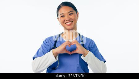 Glückliche asiatische Frau, Porträt und Arzt mit Herzhänden für die Liebe im Gesundheitswesen vor einem weißen Studiohintergrund. Weibliche Person, medizinische Krankenschwester oder Stockfoto