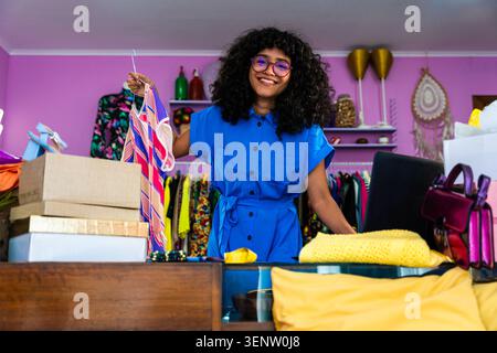 Schöne junge hispanische Frau, die ihr Heimbekleidung E-Commerce-Geschäft von zu Hause aus verwaltet - weibliche Unternehmerin besitzt Online-Shopping-Shop, Konzepte Stockfoto