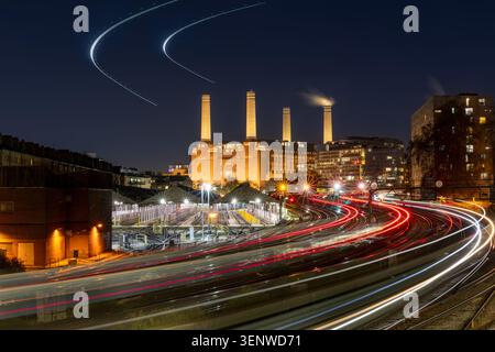 Battersea Power Station beleuchtet bei Nacht mit Eisenbahnlinien im Vordergrund, London, England, Großbritannien. Stockfoto