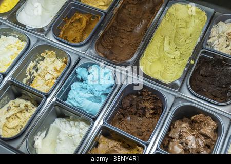 Verschiedene klassische und einzigartige Eissorten und Eis in einer gekühlten Vitrine, die eine erfrischende und süße Dessert-Auswahl für Summe bietet Stockfoto