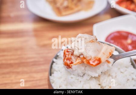 Traditionelle koreanische Gerichte umfassen frische große Biventilen, die in einer klaren Brühe gekocht werden, kombiniert mit gedämpftem weißem Reis und verschiedenen Beilagen wie scharfen Kimchi Stockfoto