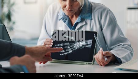 Hände, Arzt und Patient mit Tablette für Röntgenuntersuchung, Testergebnisse oder medizinische Eingriffe im Krankenhaus. Menschen, medizinisches Fachpersonal oder Knochenstruktur mit Stockfoto