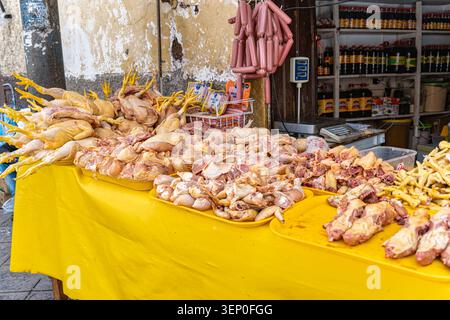 Auf einer gelben Tischplatte vor dem San Pedro Market cusco steht ein Haufen frischer, roher Hühner mit auffälliger gelber Haut und Beinen Stockfoto