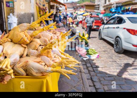 Auf einer gelben Tischplatte vor dem San Pedro Market cusco steht ein Haufen frischer, roher Hühner mit auffälliger gelber Haut und Beinen Stockfoto