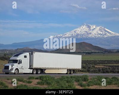 Weißer Semi Truck auf dem Highway mit Mount Shasta in Nordkalifornien Stockfoto