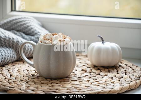 Herbstliche Schokolade oder Kaffee mit Marshmallows und Zimt auf der Fensterbank. Herbstgetränk. Nahaufnahme. Stockfoto