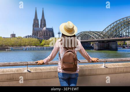 Rückansicht einer Touristenfrau auf einer Besichtigungstour durch Köln, Deutschland, mit Blick auf den Sommertag des berühmten Doms Stockfoto