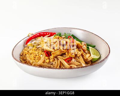 Köstliches Pad thai mit Hühnchen Erdnüssen Bohnensprossen rote Chili Limette Koriander grüne Zwiebeln weiße Schüssel isoliert. Asiatische Küche Nudelgericht. Traditionell Stockfoto