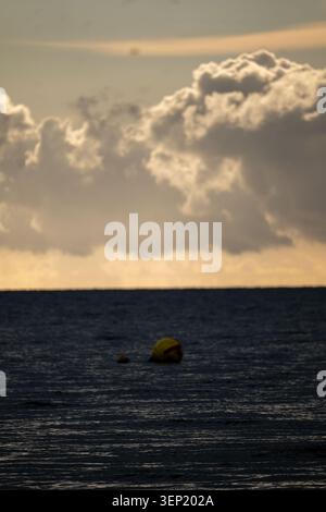 Gelbe Navigations-Boje schwimmt auf der dunklen Nordsee mit dramatischen Sturmwolken in der Abenddämmerung Stockfoto