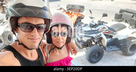 Ein Paar trägt Helme und Sonnenbrillen, bereit für ein Quad-Bike-Abenteuer Stockfoto