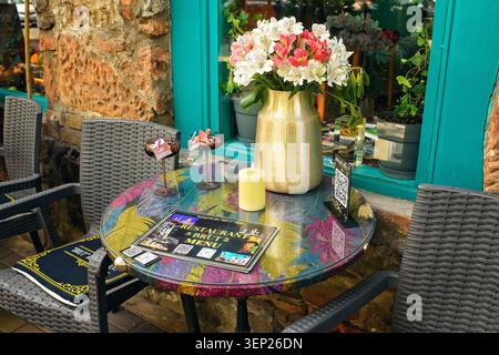 Batumi, Georgia - 09. Juni 2026: Gemütliches Straßencafé mit Terrasse, Tisch mit frischen Blumen und Cocktails an einem Sommertag Stockfoto