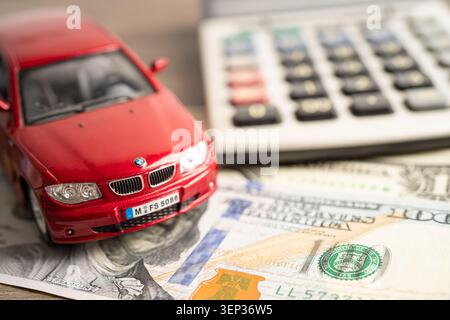 BANGKOK, THAILAND - 12. FEBRUAR 2023, Auto auf Münzen Hintergrund; Autokredit, Finanzen, Sparen, Versicherung und Leasingzeit Konzepte. Stockfoto