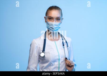 Weibliche Ärztin trägt Gesichtsmaske und Schutzbrille Stockfoto