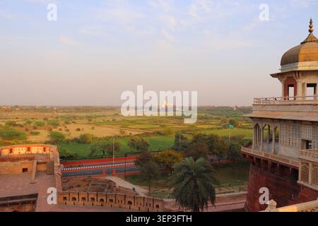 Weitwinkel-Stadtpanorama vom Dach des Agra Fort mit dem berühmten Taj Mahal, das in der Ferne über die Landschaft sichtbar ist. Stockfoto