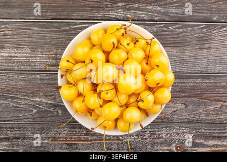 Gelbe Kirschschale auf Holzhintergrund, Draufsicht Stockfoto