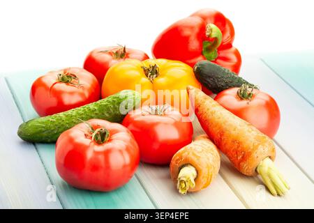 Rosa gelbe Tomatengemüse auf blauem Holzhintergrund auf weiß Stockfoto
