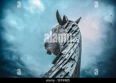Niedriger Blickwinkel der Kelpies-Stahlskulptur mit Pferdekopf unter dramatischen Wolken in Falkirk, Schottland Stockfoto