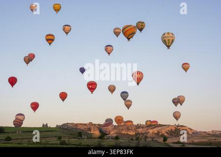 Malerische Aussicht auf farbenfrohe Heißluftballons, die über die einzigartige Landschaft Kappadokiens, Türkei, fliegen Stockfoto