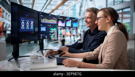 Zwei Finanzanalysten teilen Einen freudigen Moment, während sie Daten gemeinsam prüfen. Stockfoto