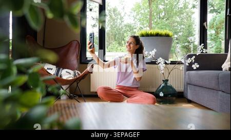 Frau filmt sich selbst und genießt zu Hause eine gesunde Frühstücksschale Stockfoto