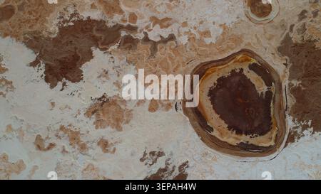Geradliniger Blick auf einen natürlichen Heißwasserteich, der von komplexen Salzkrusten und geothermischen Mineralringen in der Danakil-Depression umgeben ist Stockfoto