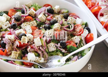 Griechischer Salat mit Fetakäse, Oliven und frischem Gemüse. Gesunde mediterrane Mahlzeit serviert in Schüssel Closeup. Stockfoto