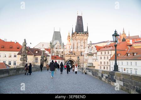 Prag, Tschechische Republik, 28. Dezember 2025, Ein malerischer Blick auf die historische Karlsbrücke in Prag, mit Fußgängern, die auf dem Kopfsteinpflaster spazieren Stockfoto