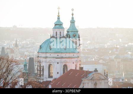 Prag, Tschechische Republik, 27. Dezember 2025, Ein atemberaubender Blick auf die grüne Kuppelkirche St. Nikolaus in Prag, Tschechische Republik, gebadet in sanftes Gold Stockfoto