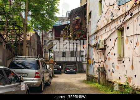 Batumi, Georgia - 09. Juni 2026: Gemütliche Wohnstraße im historischen Zentrum mit authentischen Häusern, Holzgitterbalkonen, geparkten Autos Stockfoto