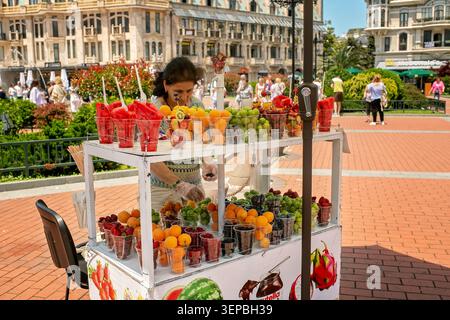 Batumi, Georgia - 9. Juni 2026: Straßenhändler mit frischem Obst, Beeren und Wassermelonen in Plastikbechern zum Mitnehmen auf dem Europe Square. Stockfoto