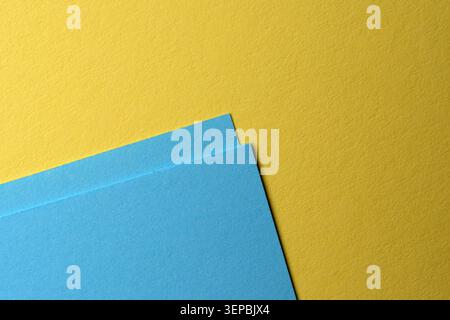 Hellblaue und leuchtend gelbe Papiere sorgen für eine fröhliche Atmosphäre am Arbeitsplatz. Stockfoto