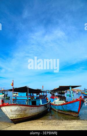 Traditionelle hölzerne Fischerboote vor Anker an der Sandy Shore unter dem blauen Himmel Stockfoto