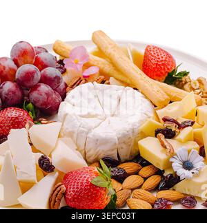 A platter includes different types of cheese, grapes, strawberries, nuts, and crackers arranged for a gathering. This food display invites guests to enjoy snacks together. Stockfoto
