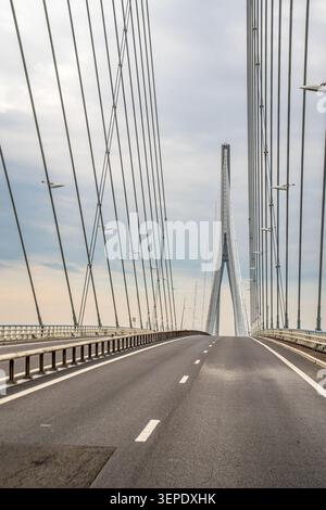 Eine Nahaufnahme der leeren Asphaltstraße auf der Normandie Bridge. Die Seiten der Fahrbahn werden von den dichten vertikalen Linien von s dominiert Stockfoto