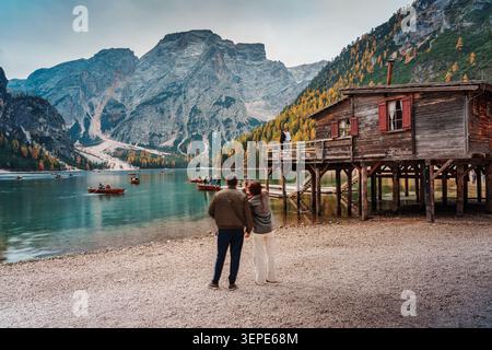 Südtirol, Italien - 19. Oktober 2025 : berühmter Pragser See mit Holzboothaus und Touristen, die Ruderboot besuchen und von alpinen Bergen umgeben Stockfoto
