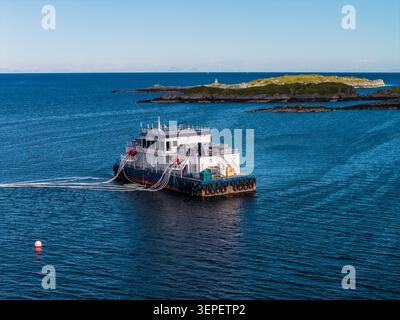 Luftlachsfutterkahn in der Nähe von Lofoten, Norwegen in ruhiger See Stockfoto