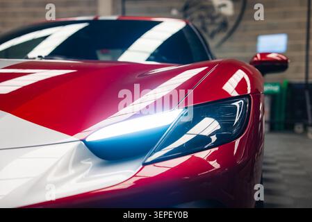 Ferrari 296 GTB vorn links in der Werkstatt mit LED-Leuchte Stockfoto