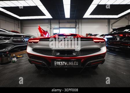 Rückansicht Ferrari 296 GTB in moderner Werkstatt mit automatischer Detaillierung Stockfoto