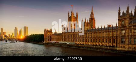 Ein atemberaubender Blick auf den Sonnenuntergang auf den ikonischen Palast von Westminster und die Themse in London. Das warme Licht des Abendlichts beleuchtet die Geschichte Stockfoto