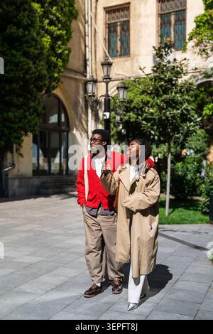 Fröhliches afroamerikanisches Paar, Mann und Frau in der Stadt, lächelnd und amüsierend. Stockfoto