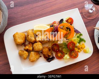 Eingelegter Dogfish mit gehacktem Gemüse auf weißem Teller Stockfoto