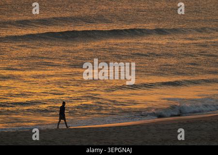 Spaziergänger am Strand, untergehende Sonne färbt das Meer und die Wellen Golden, Houvig Beach, Nordsee, Dänemark Stockfoto