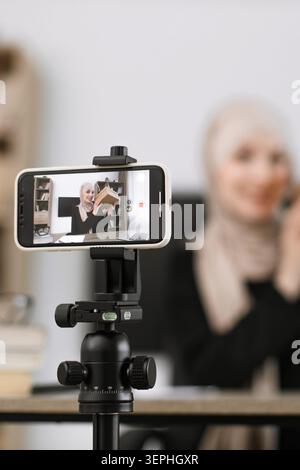 Frau filmt Buchrezension am Telefon Stockfoto
