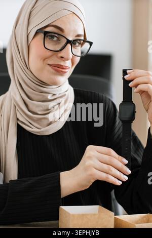 Frau in Hijab mit Smartwatch Stockfoto