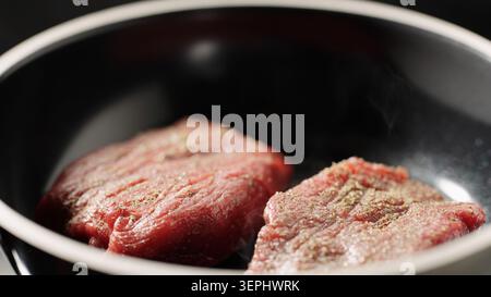 Nahaufnahme von zwei Rinderfilet-Steaks, die in einer heißen Pfanne anbraten Stockfoto