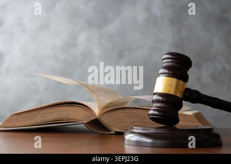 Gerichtsbarabel in der Nähe eines offenen juristischen Buches, mit Seiten in Bewegung, die Gerechtigkeit, Rechtsstudium, juristische Autorität, Urteile, und gerichtliche Entscheidungen verheimlichen Stockfoto