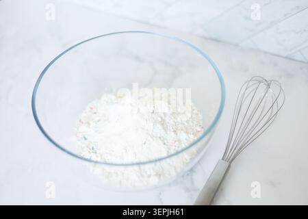 Funfetti-Tortenmischung in einer Glasschale mit Schneebesen Stockfoto